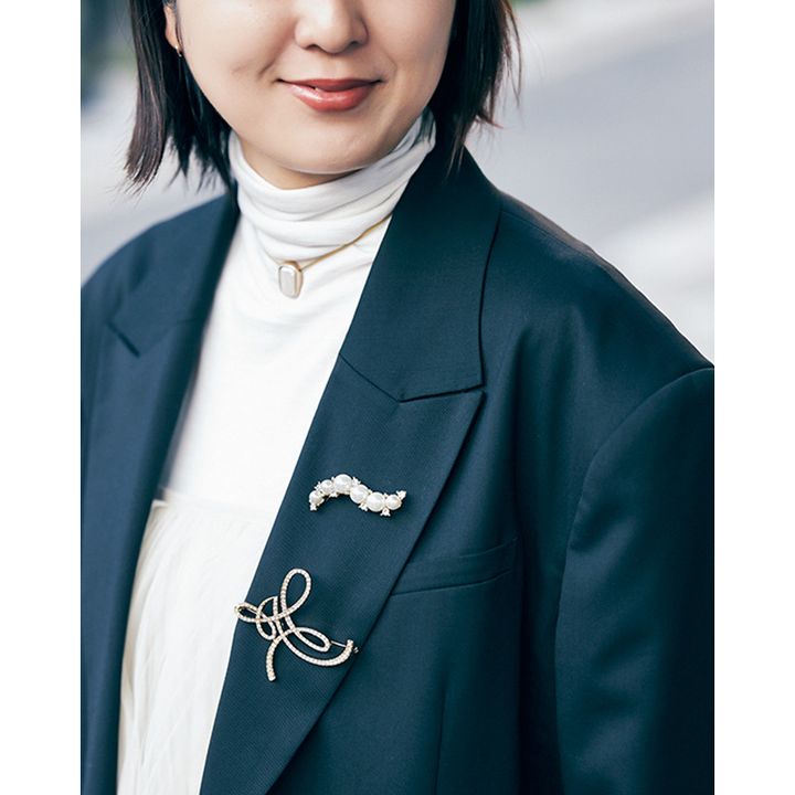 ブローチを2個つけたジャケットの胸元