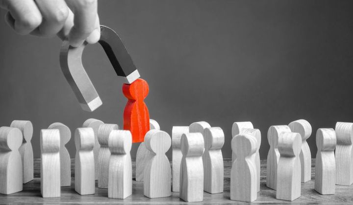 ビジネスマンは磁石で灰色の群衆から赤い人形を引き出す