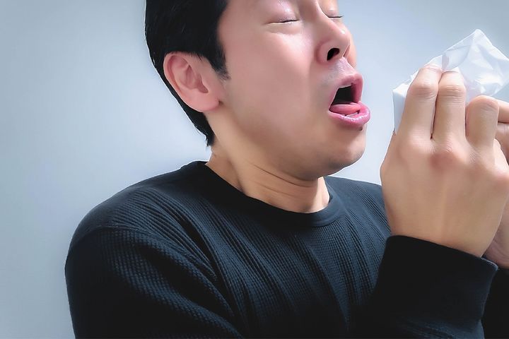 マスクせず咳・くしゃみをしている人のイメージ