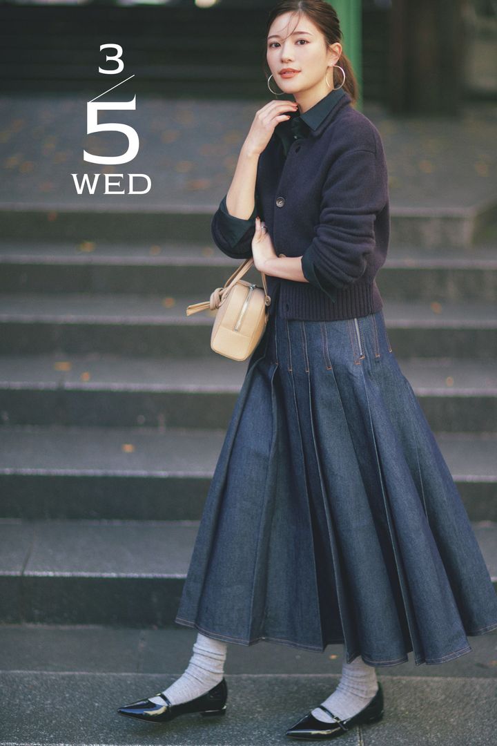 シャツにカーデを重ねて太いプリーツのデニムスカートを合わせた着こなし