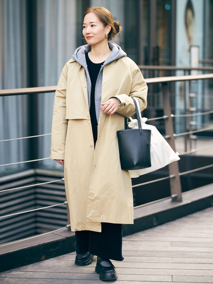 グレーパーカに黒インナー、パンツのベージュカラートレンチ