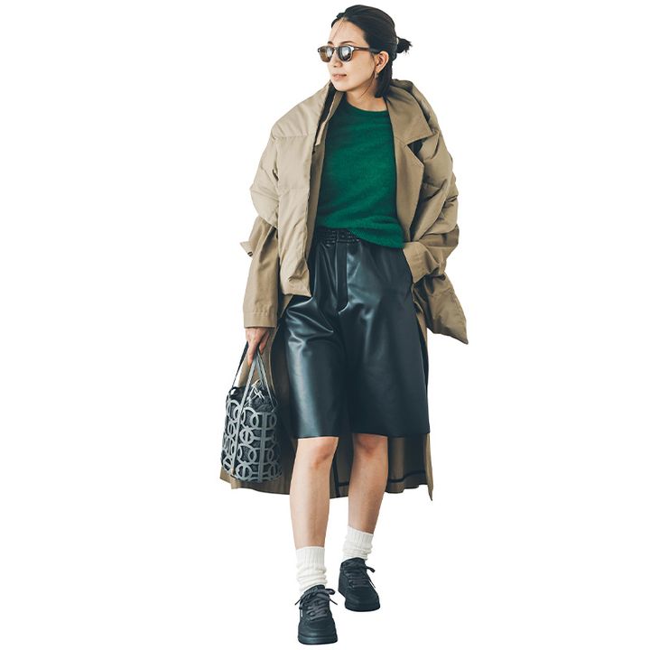黒レザーハーフパンツに緑のニット、ダウンストールにトレンチ