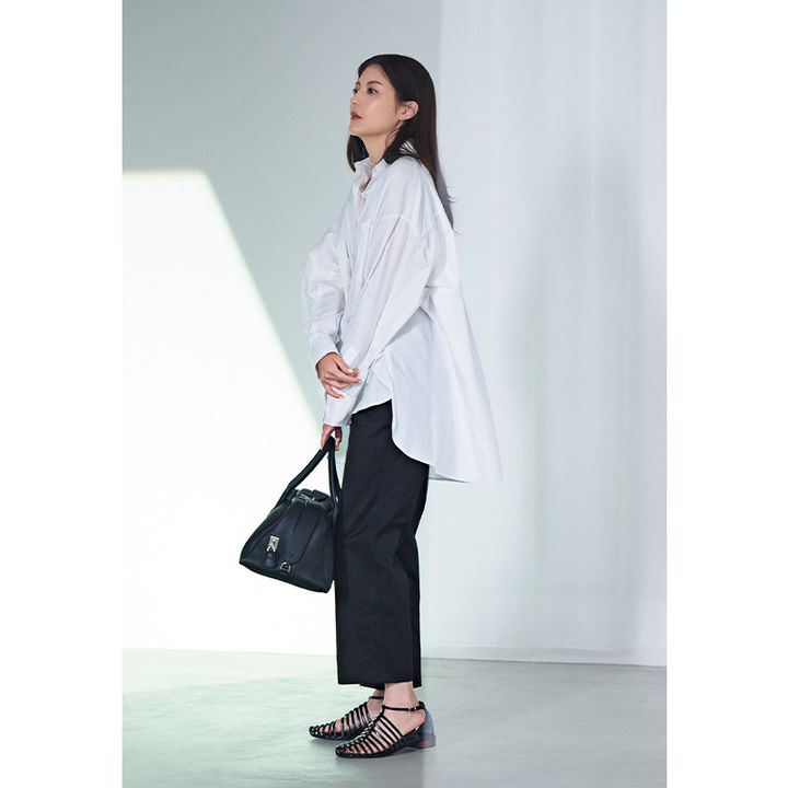 オーバーサイズの白シャツに黒パンツのワンツーコーデに黒のボストンバッグとサンダルを合わせた佐藤ありささん