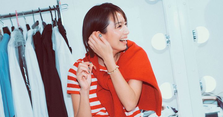 赤のボーダーTシャツに赤ニットを肩掛けして笑う東原亜希さん