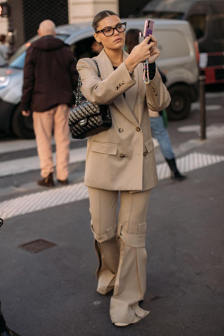 画像: 優雅なベージュスーツとメガネがマッチ