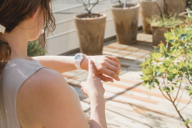 外で運動する女性 時計をチェック