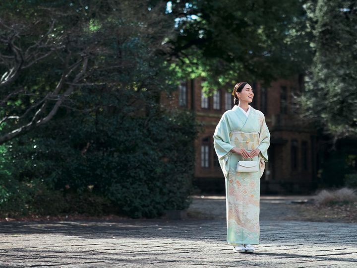 淡いグリーン系の着物に白いバッグを合わせた笹川友里さん