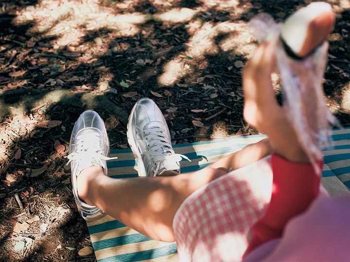 ピンクのギンガムチェックのスカートにホーガンのシルバーのスニーカーを合わせた足元