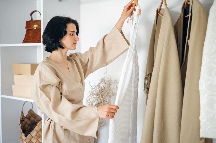 自室で服を選ぶ女性