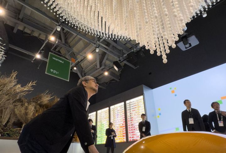 「一生分のたまご」の展示はパビリオン随一のフォトスポットだと小山薫堂氏。自ら下から一生分の卵を食べているようなポーズを取ってくれた。