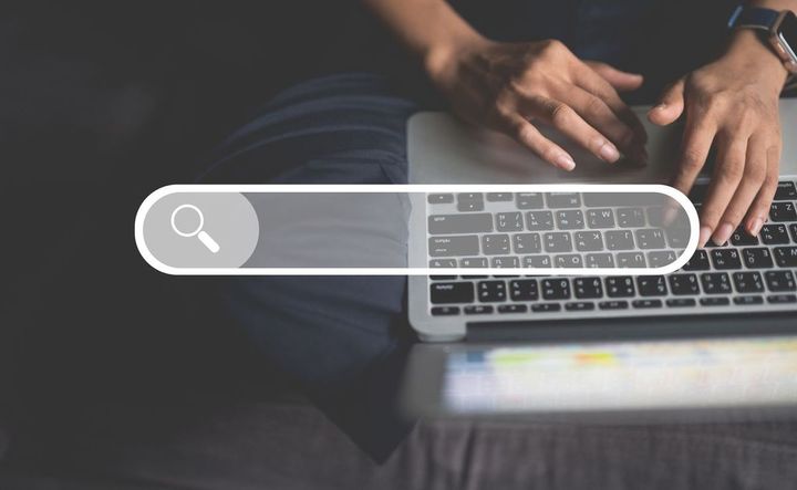 ラップトップで検索する男性の手元
