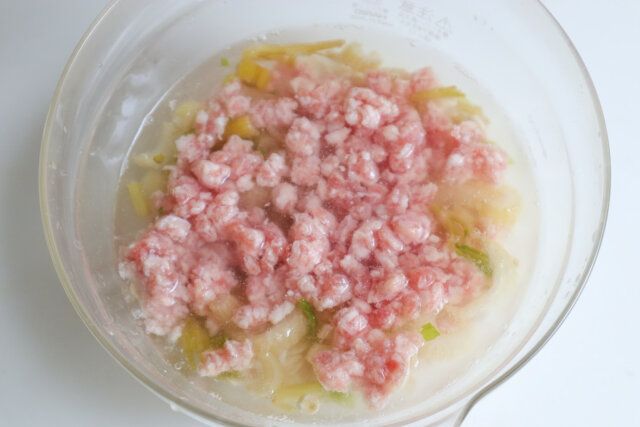 耐熱容器にオートミール、水、塩を入れ、セロリの茎、豚ひき肉をのせて広げる。