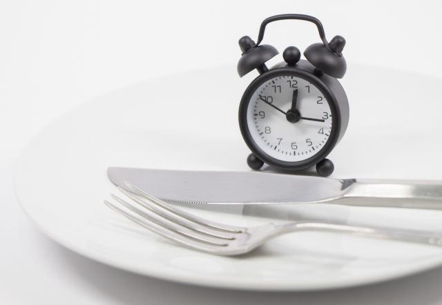 お皿の上に乗った時計とナイフとフォーク ダイエットイメージ