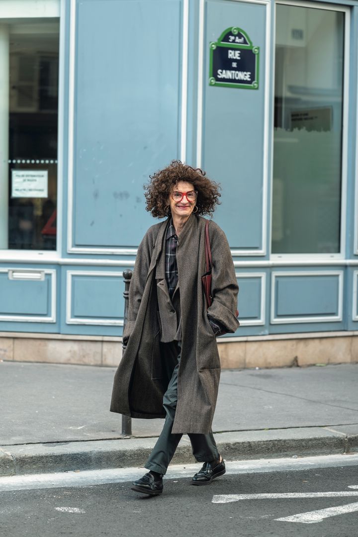 赤いフレームのメガネにボリューミーなパーマヘアがよく似合う