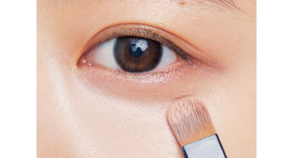 キワをはずした目の下全体にブラシでなじませ、クマとくすみをカバー。