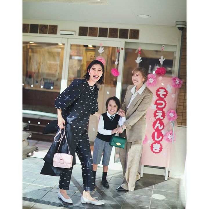 リボンツイードのパンツセットアップにパールジュエリーやピンクのバッグを合わせたママとフォーマルコーデの息子と祖母