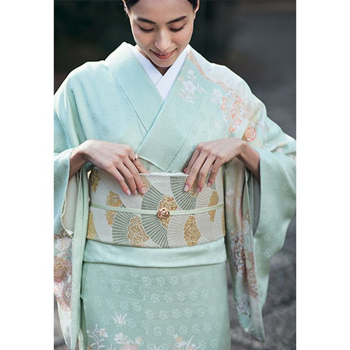 和装姿で帯揚げを指で押し込む笹川友里さん