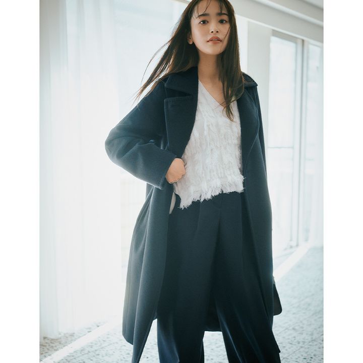 白のフリンジトップスとパンツにマックスマーラの濃紺色コートを羽織った近藤千尋さん