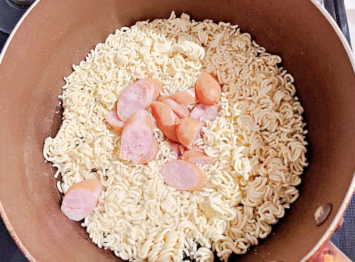 鍋に砕いた麺とウインナーを入れて火にかける