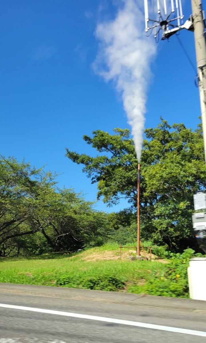 道沿いに吹き出している湯けむり風景