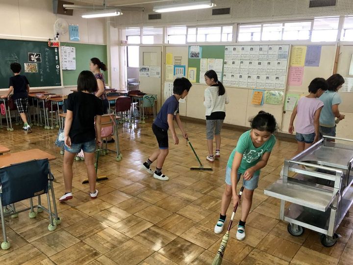 小学校の教室で、児童たちが清掃中