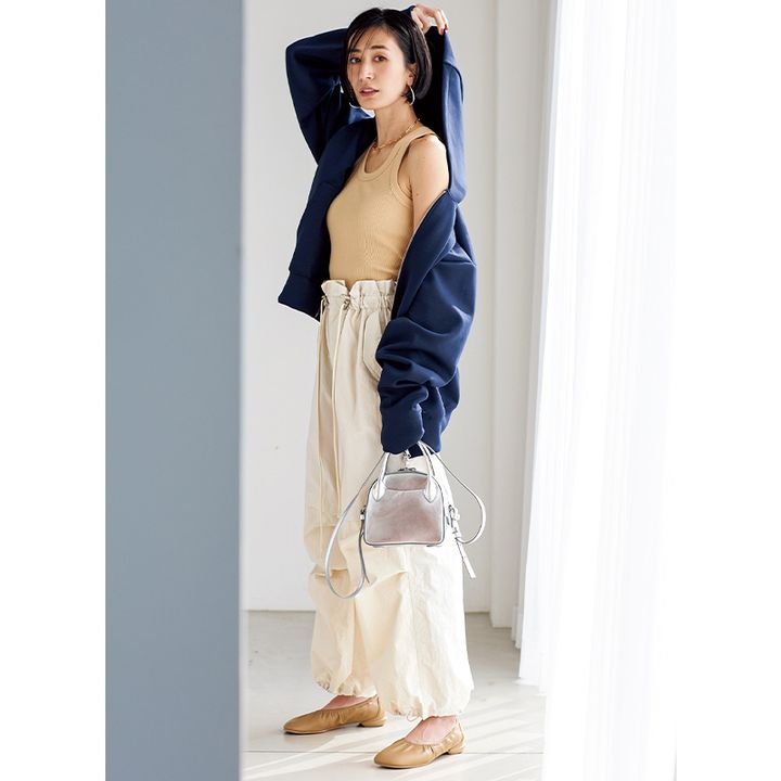 オフホワイトのパラシュートパンツ、ネイビーのシャカシャカアウターのコーデ