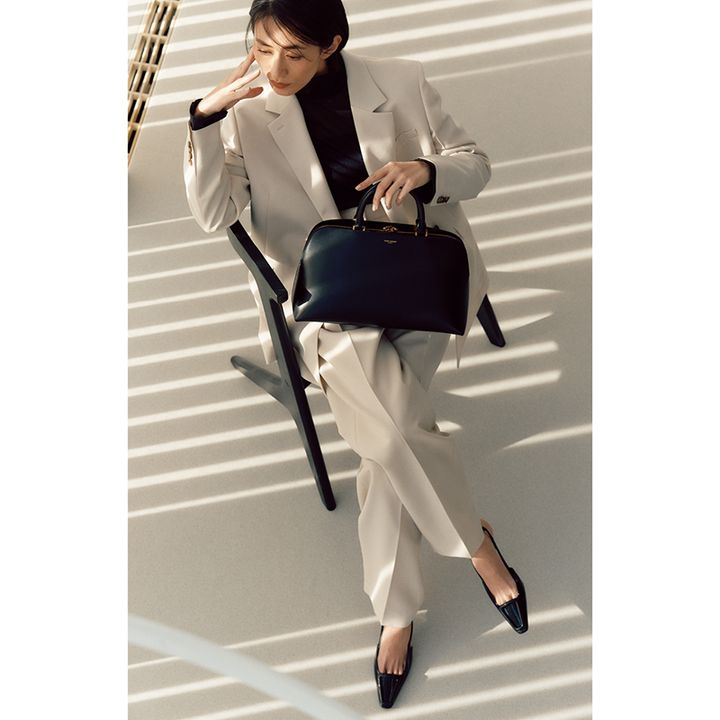 あかるめカラーのパンツスーツにシアートップス、ヒールのかっちりコーデ