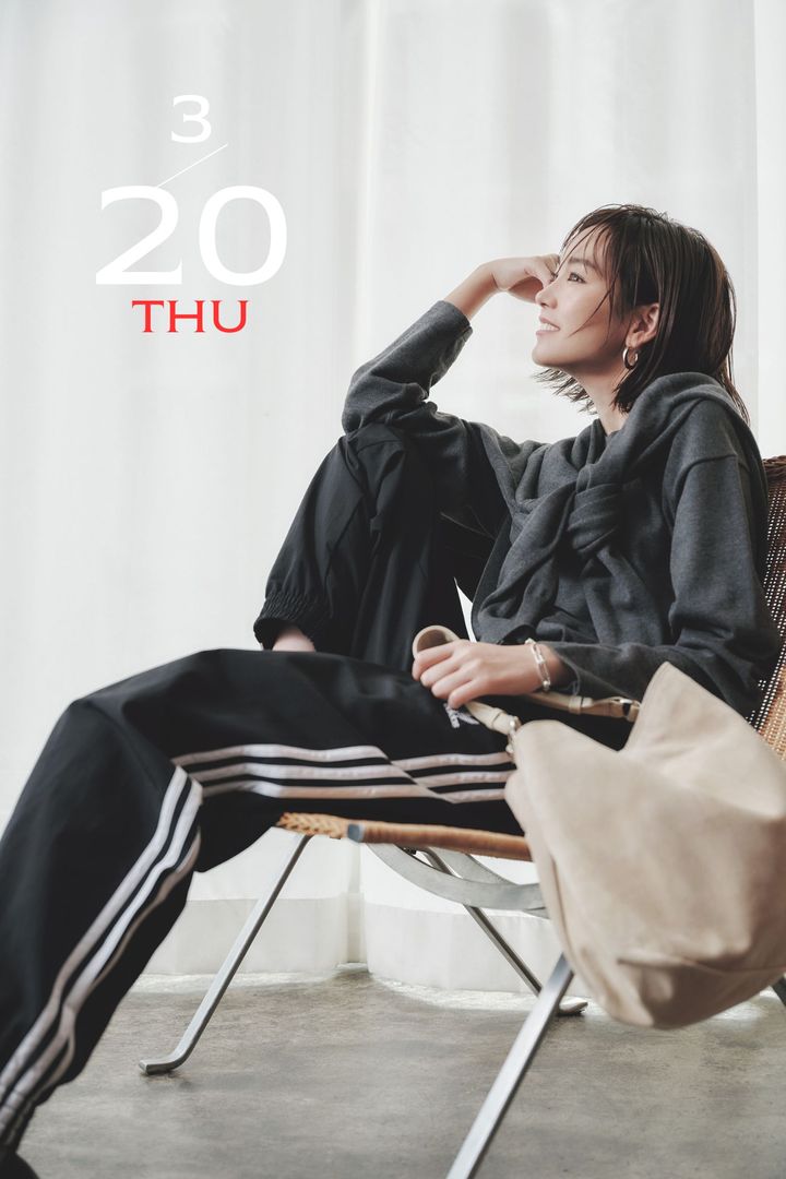 グレーのツインニットに3本ラインが入ったトラックパンツとベージュのバッグを合わせた桐谷美玲さん