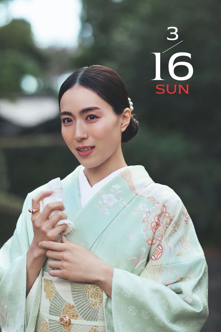 淡いグリーン系の着物に組み紐の帯留めを合わせた笹川友里さん