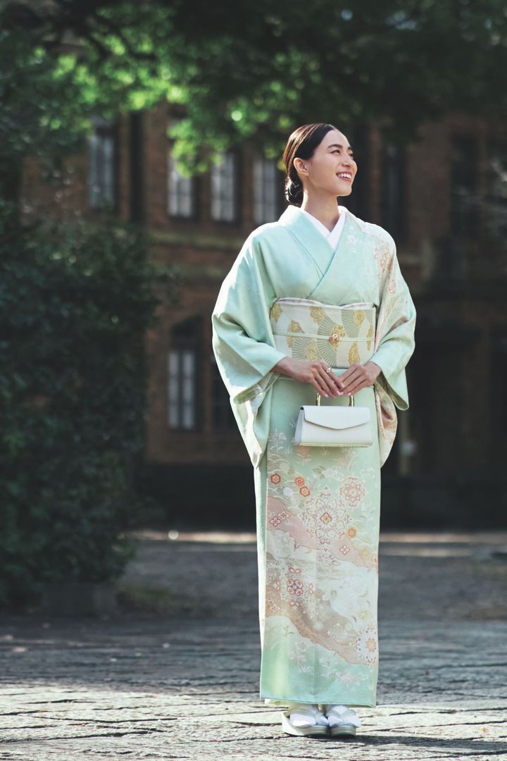 淡いグリーン系の着物に白いバッグを合わせた笹川友里さん