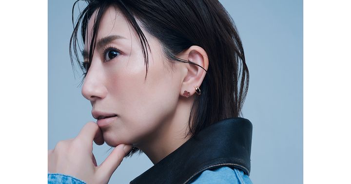 左耳にヴァンクリーフ＆アーペルのカーネリアンのスウィートアルハンブラとカルティエのジュストアンクルのシングルフープピアスを2個付けした東原亜希さん