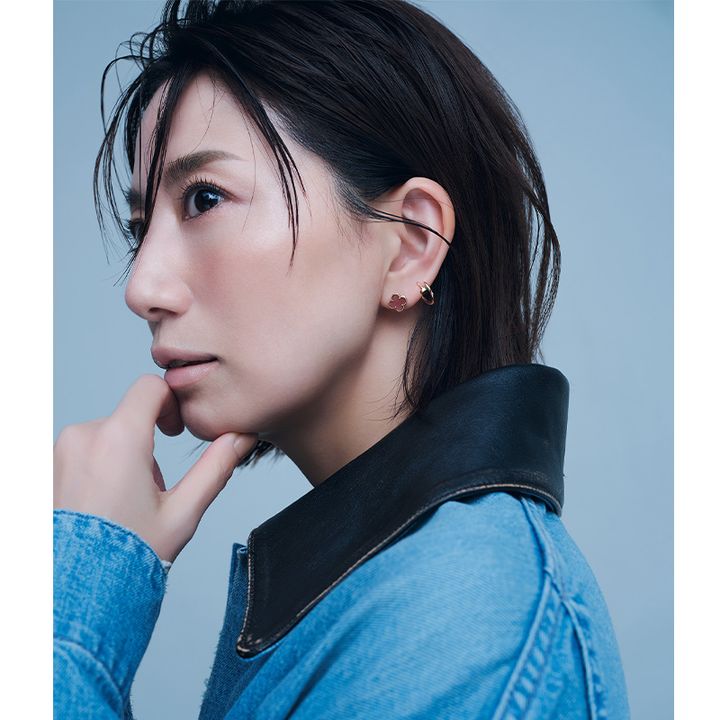 左耳にヴァンクリーフ＆アーペルのカーネリアンのスウィートアルハンブラとカルティエのジュストアンクルのシングルフープピアスを2個付けした東原亜希さん