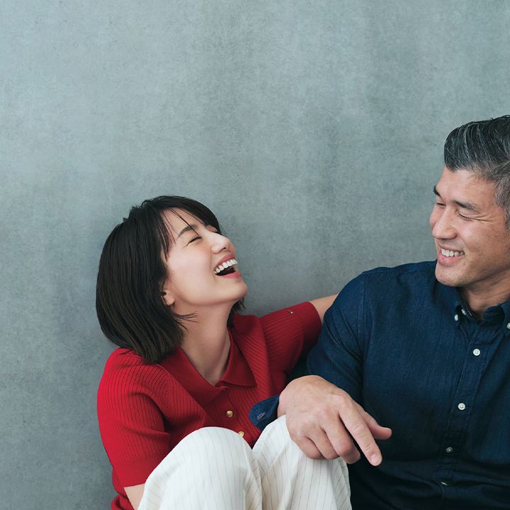 赤のポロニットと白のパンツを穿いて夫の井上康生さんと笑い合う東原亜希さん