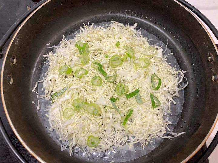 千切りキャベツとねぎをのせる
