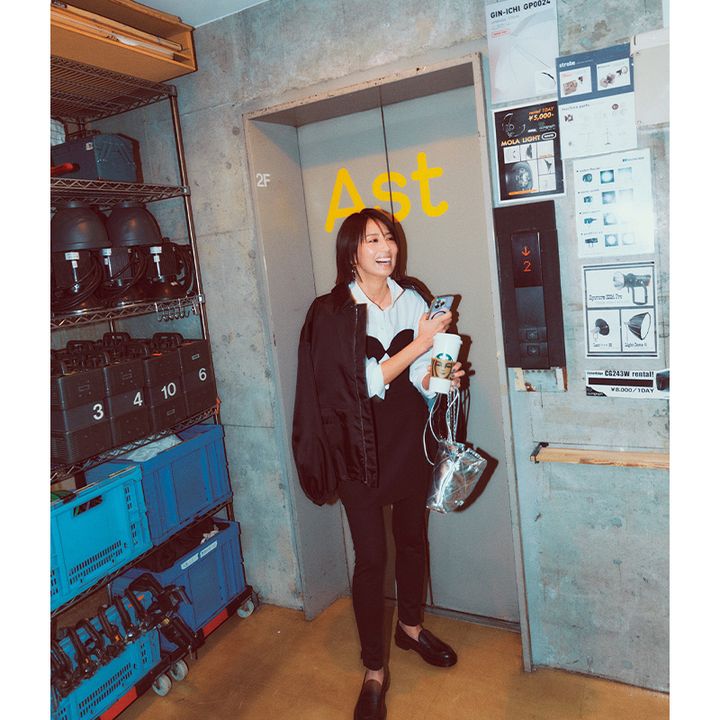 白シャツにビスチェを重ねてブルゾンを羽織って黒パンツを合わせた東原亜希さん