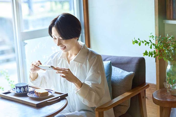 カフェで写真を撮る女性