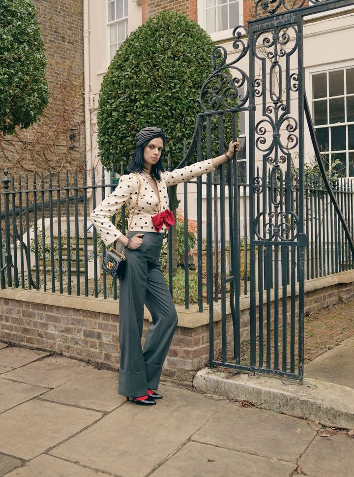 “モア・イズ・モア”の真骨頂 伝説的なスーパーモデル、クリステン・マクメナミーの娘で、自身もユニークでアーティスティックな魅力を武器にモデルとして活躍する リリー・マクメナミー。ドットのジャケットに真っ赤なボウをあしらった、ヴァレンティノのクリエイティブ・ディレクター、アレッサンドロ・ミケーレらしいマキシマリズムを感じるスタイル。足もとにも、同じく赤の差し色を入れて細部まで抜かりなく。<br /> ジャケット ¥676,500 パンツ ¥291,500 タイツ ¥44,000／すべてVALENTINO ネックレス ¥378,400 バッグ 参考商品 グローブ ¥89,100 シューズ ¥203,500／すべてVALENTINO GARAVANI（すべてヴァレンティノインフォメーションデスク） ターバン／EMILY-LONDON（www.emily-london.com）