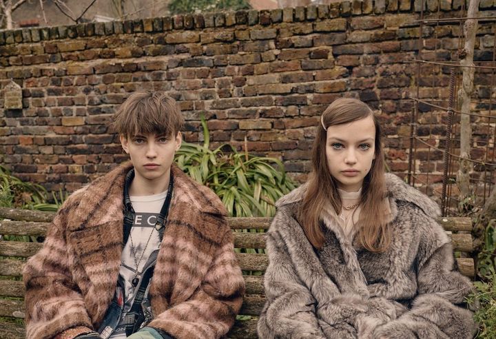 柔和をもたらすアーストーン ともにモデルとして活動するウィリアム・コートとエレノア・ムーディ兄妹は質感豊かなアウターでシンクロコーデに。グッチのフラッフィーなコートは、サカイの透け感のあるトップとカルティエのネックレスでレディにまとめて。モスキーノの温かみのあるチェックコートは、纏う人の優美な内面を映し出す。<br /> 〈右〉コート 参考商品／GUCCI（グッチ クライアントサービス） トップ 参考商品／SACAI（サカイ） 「トリニティ」ネックレス（上）PG╳WG╳YG ¥1,755,600 ネックレス（下）PG╳WG╳YG╳ダイヤモンド ¥1,399,200／ともに CARTIER（カルティエ カスタマー サービスセンター） ヘアクリップ／スタイリスト私物 〈左〉コート／MOSCHINO（www.moschino.com） シャツ Tシャツ ネックレス／すべてモデル私物