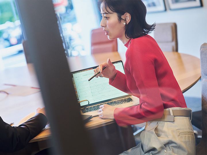 赤のリブニットにベージュのパンツとベルトを合わせた着こなし