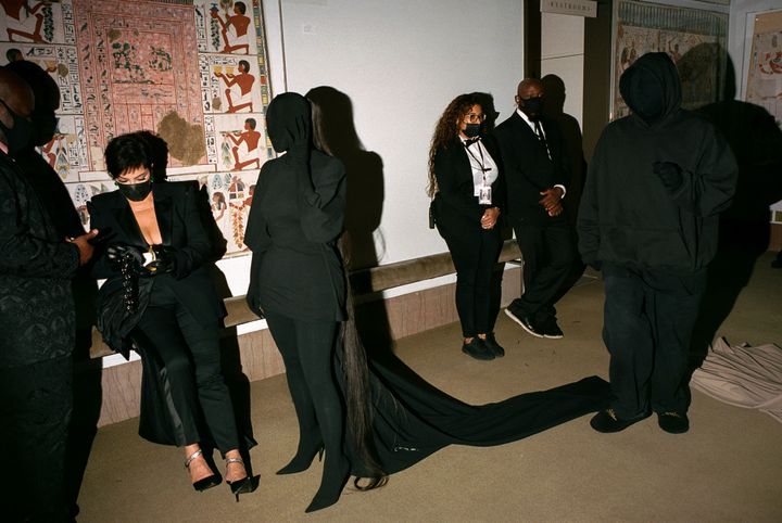 Kris Kardashian, Kim Kardashian and Demna Gvasalia stand in the among Egyptian hieroglyphs in a hallway of the 2021 Met Gala.