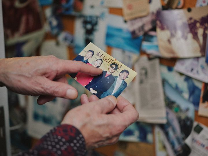 若い頃の坂本龍一の写真を見るジェレミー・トーマス