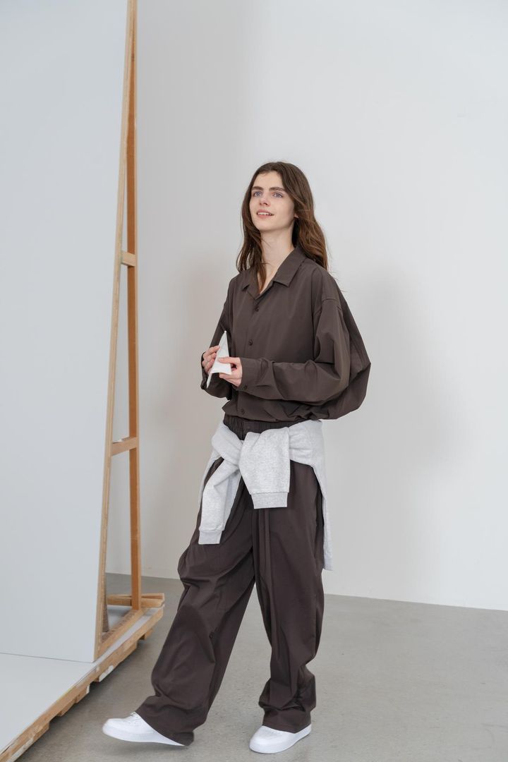 画像: 「NYLON STRETCH LONG-SLEEVE SHIRTS」￥24,200、腰に巻いた「STANDARD CREW SWEAT」￥17,600、「NYLON WIDE TAPERED PANTS」￥25,300 出典：＋ one off day