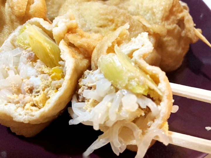 箸で持った油揚げのすき焼き風巾着