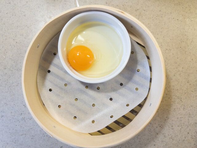 蒸籠に蒸籠シートを敷き、ココットを入れて卵を割り入れます。