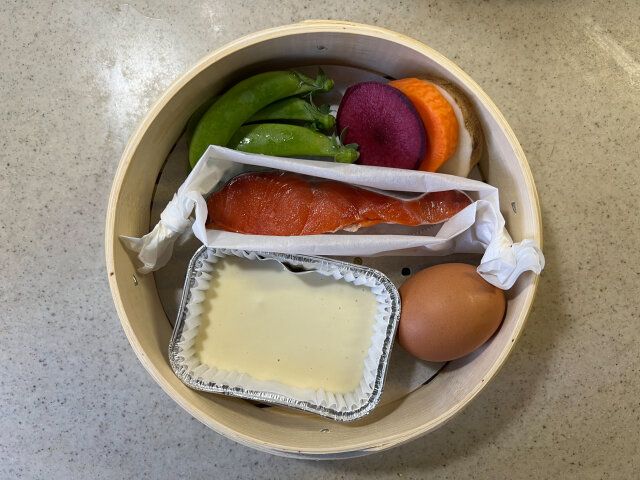 蒸籠にシャケ・スナップエンドウ・蒸しパンの材料を混ぜ合わせたもの・卵