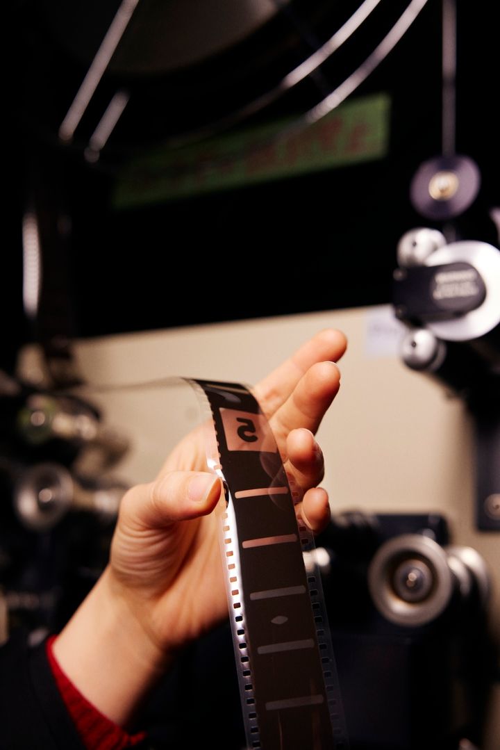 下のリールにフィルムを引っ張る村岡さんの指の間から、5秒前の数字が見える