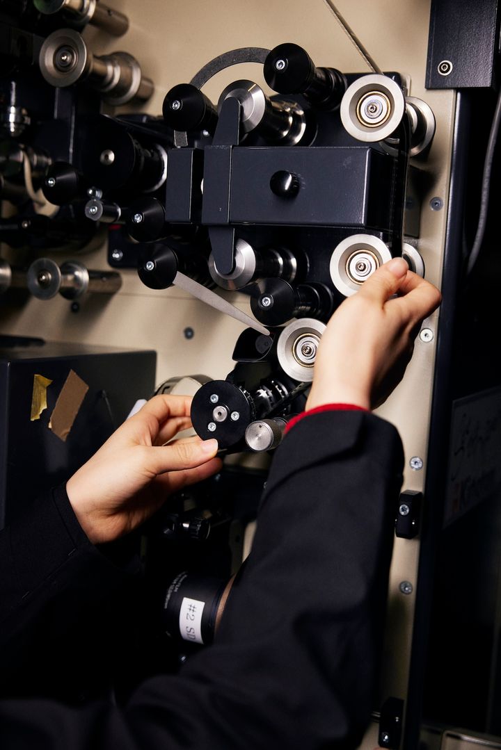 映写機にフィルムをかける手が、注意深く動いていく