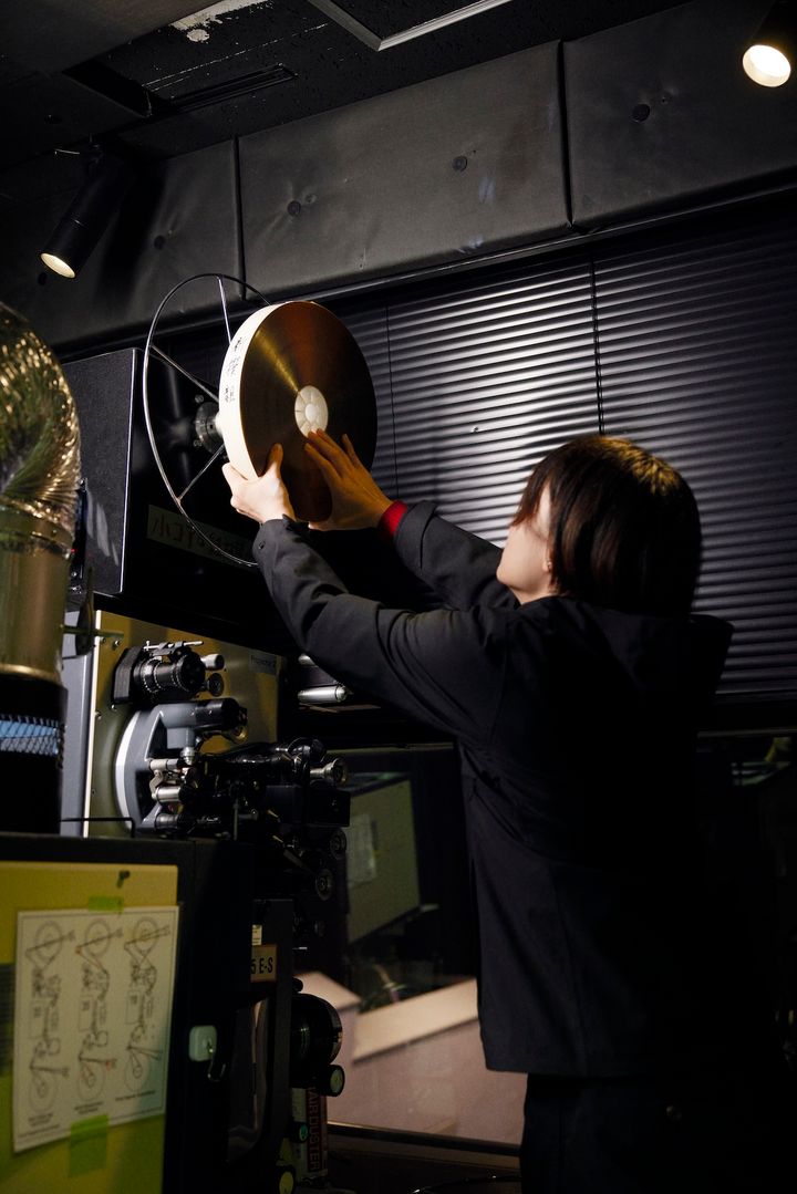 ステップに登り、フィルムを上部のリールに取り付ける