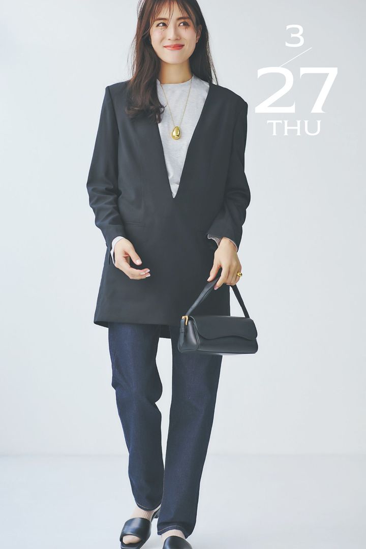 黒のVネックボトムスのインナーにグレーTシャツを合わせて濃紺ボトムスを穿いた着こなし