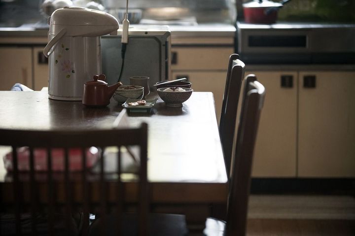 薄暗いキッチンのテーブルに用意された食事